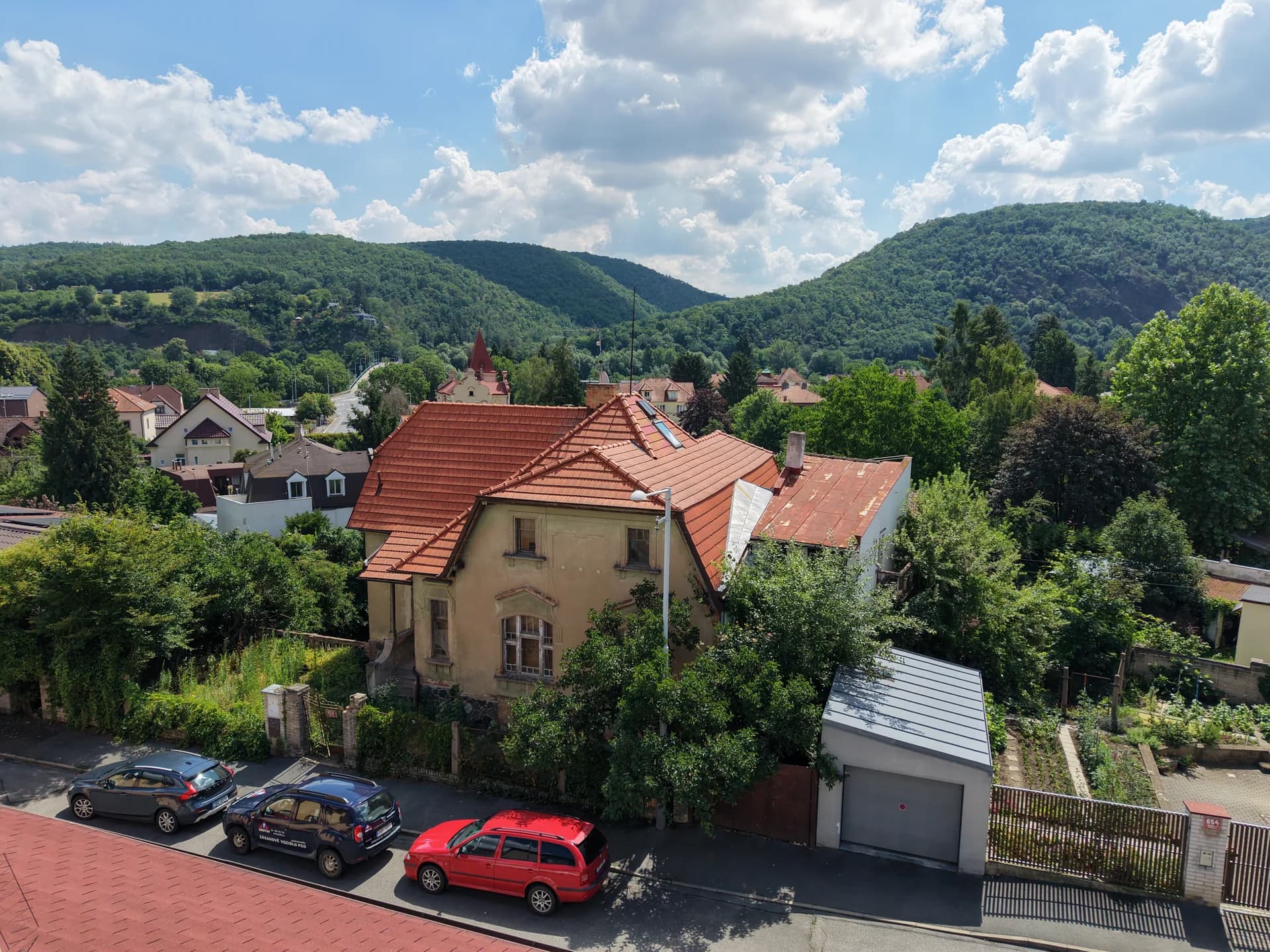 Průčelí vily ve Zbraslavi pod zalesněnými svahy